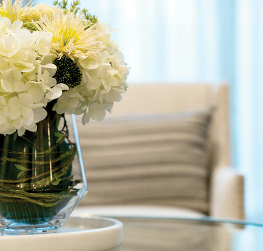 flower vase on glass table in front of couch