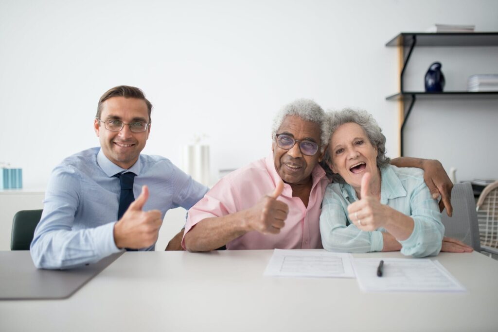 3 people sat smiling to the camera