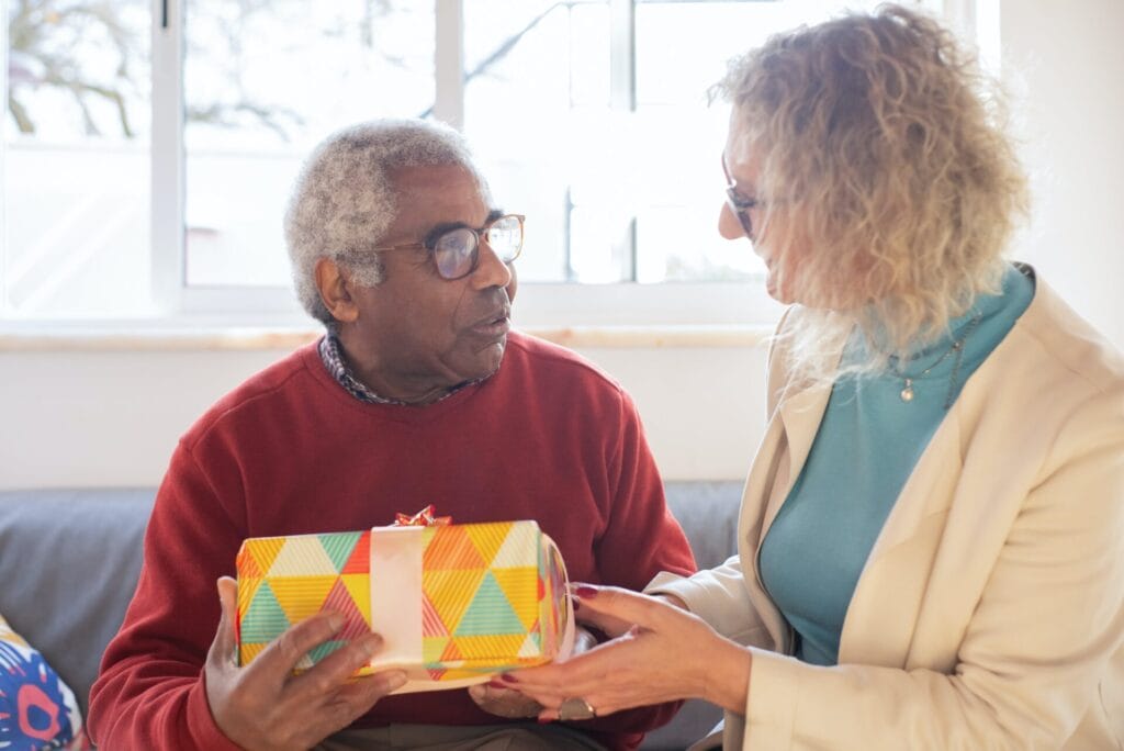 A person giving a gift to an elderly person