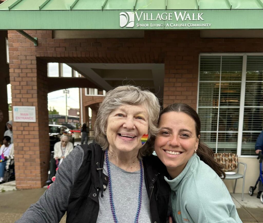 A cropped picture of a memory care resident and a younger person smiling