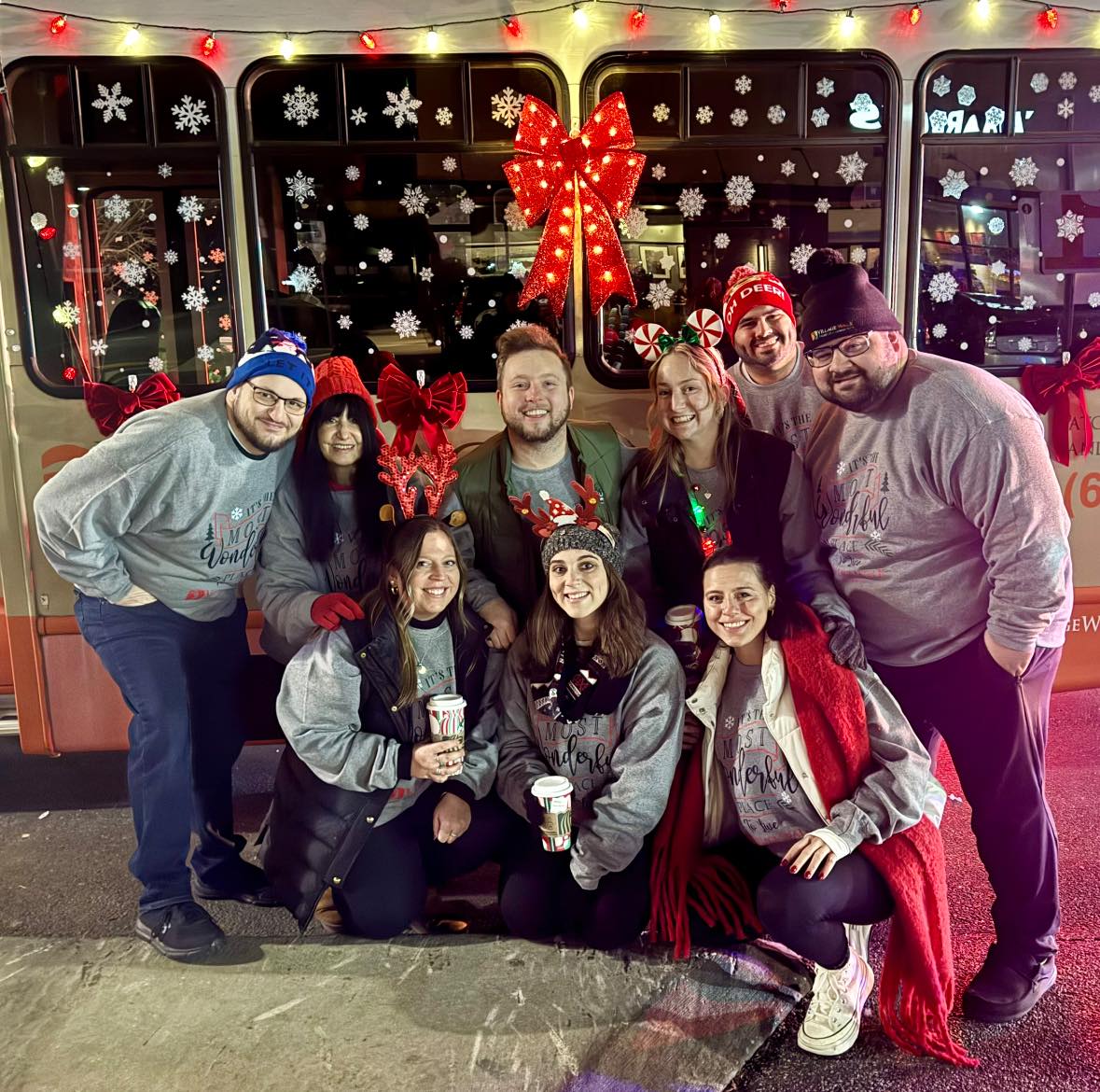 A picture of the Village Walk team smiling on Christmas at night