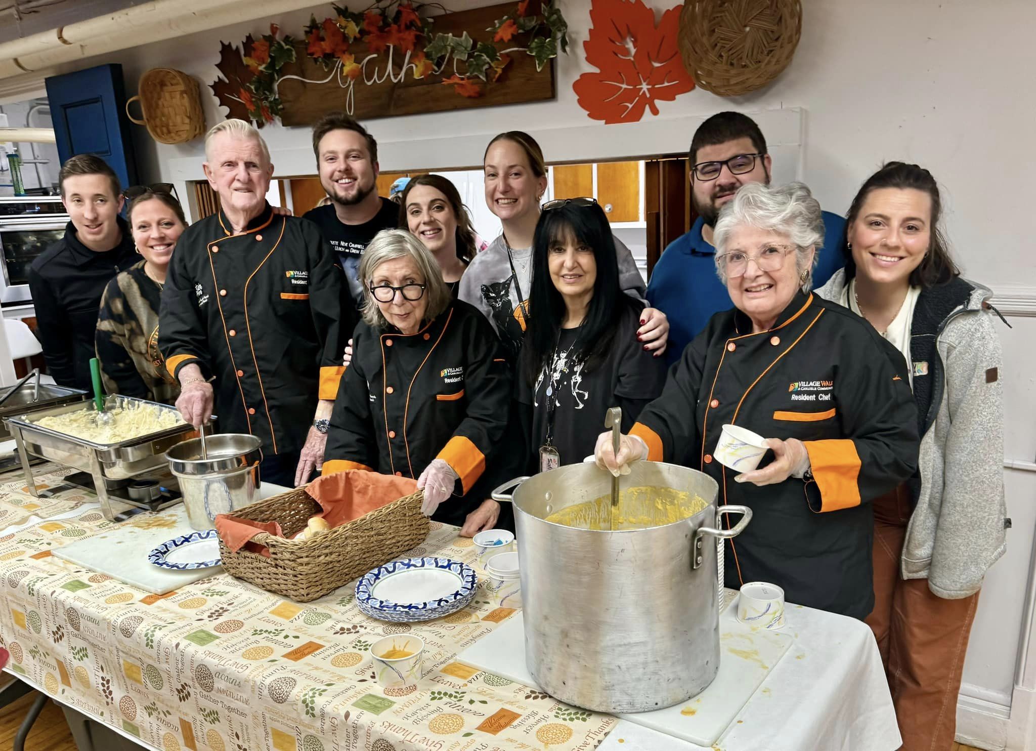 Village Walk staff around a Thanksgiving dinner table meal