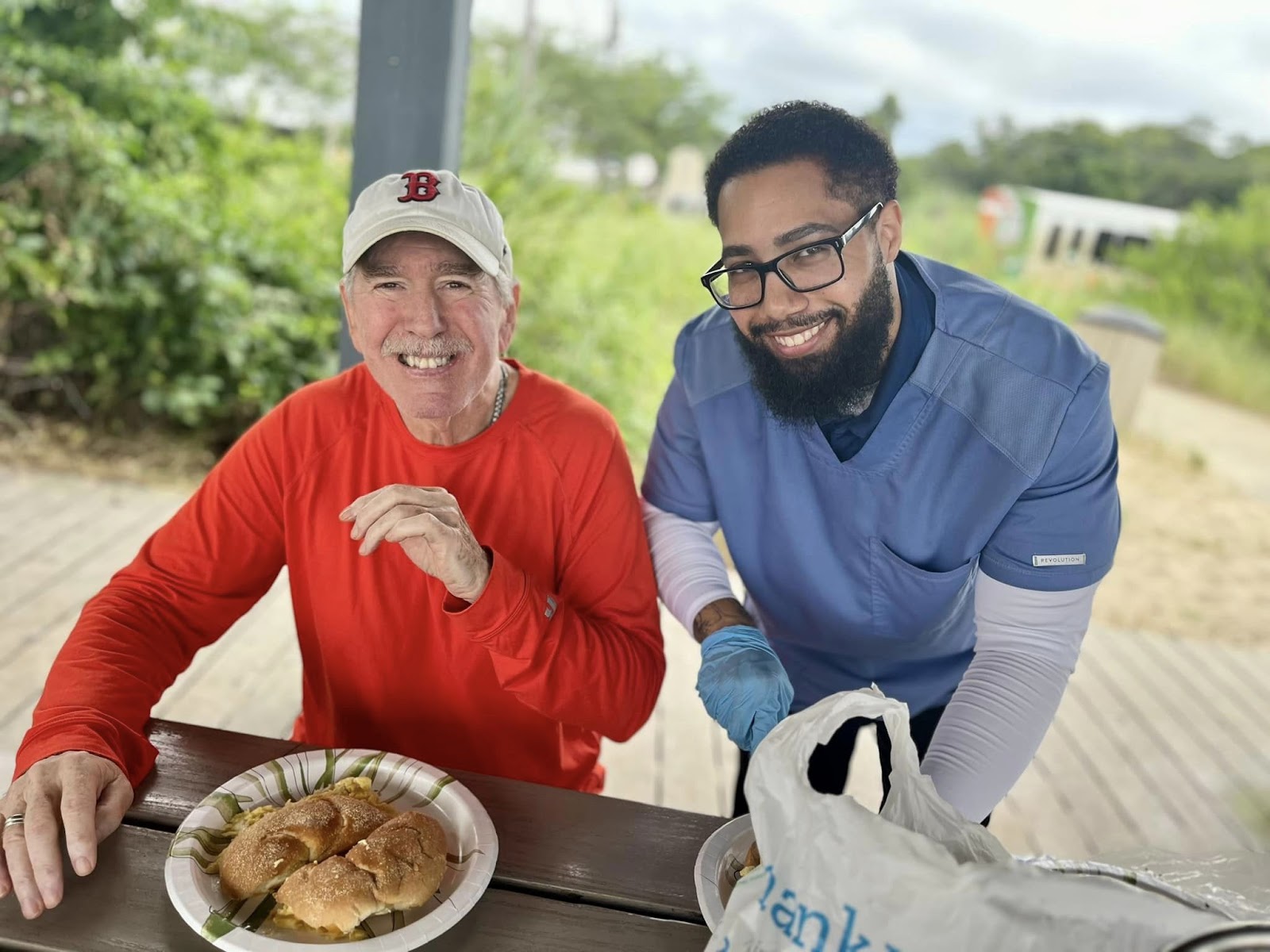 An assisted living aide smiling next to an assisted living resident