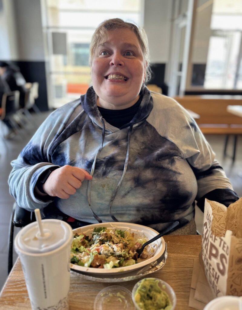 A woman eating food from Chipotle grill