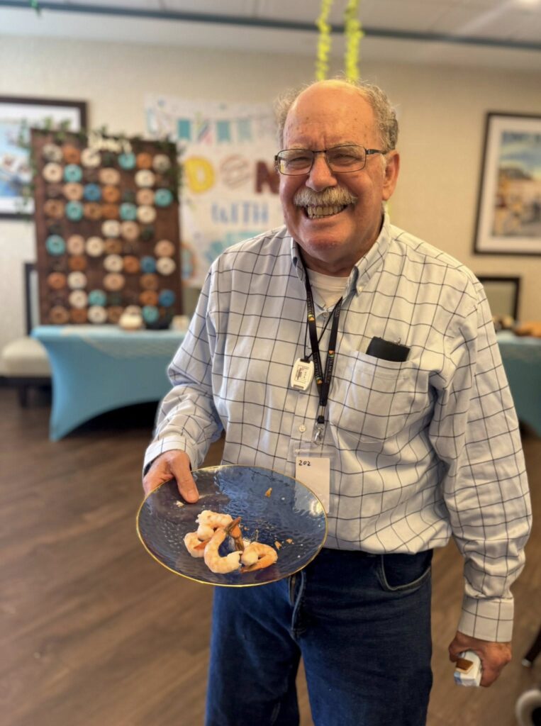 A man smiling holding a plate of food