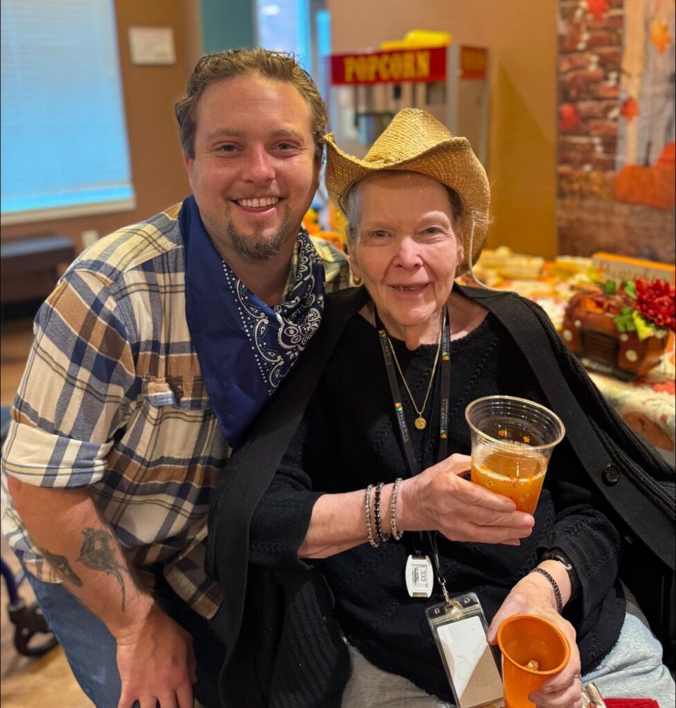 A woman and man smiling in fall attire with drinks in hand