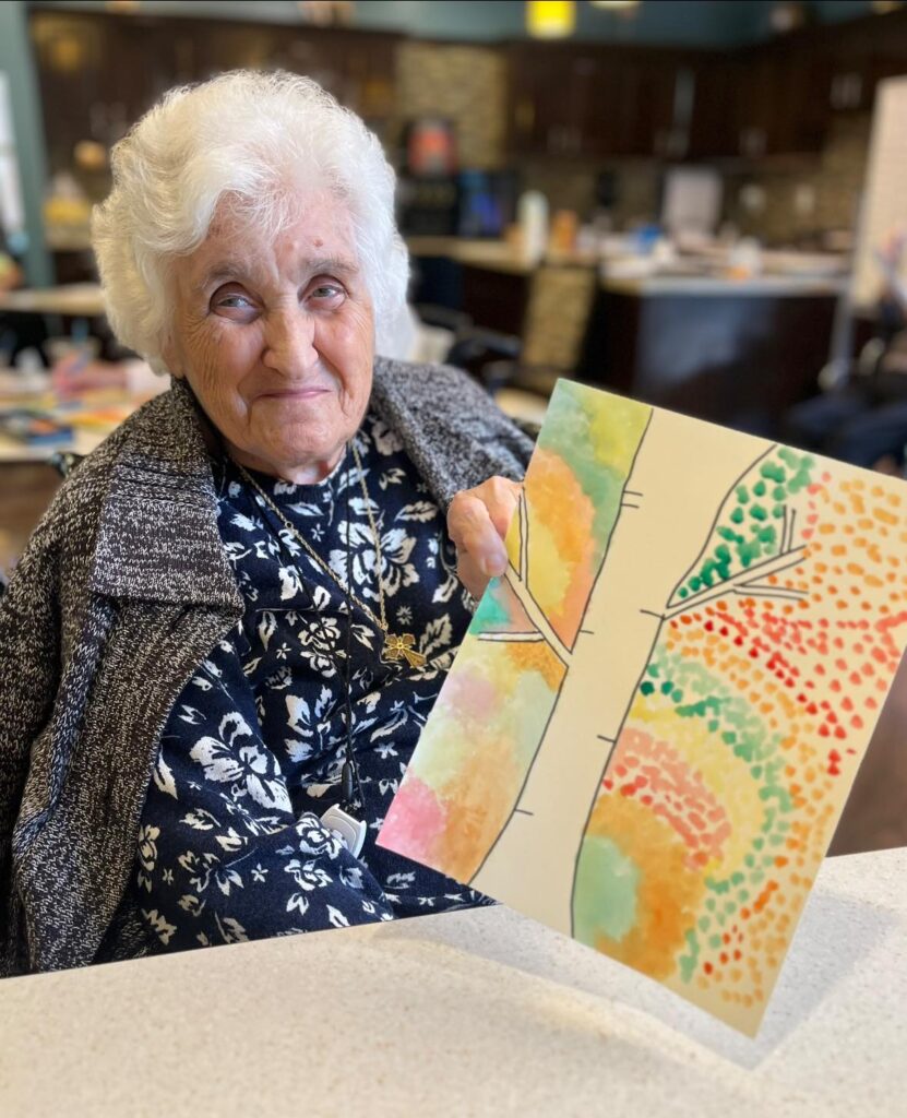 A woman in level 1 assisted living care with a hand-painted picture of a tree